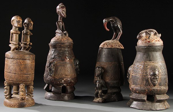 A GROUP OF FOUR CARVED WOOD AFRICAN VESSELS: A GROUP OF FOUR CARVED WOOD AFRICAN VESSELS. Comprising a Dogon-style divination bowl and three Balinese covered cups all with figures carved on lids. Greatest height 24.5 inches (62 cm).