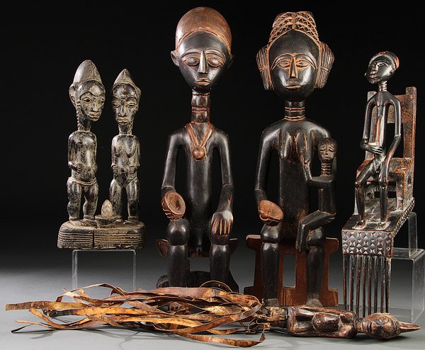 A GROUP OF FIVE CARVED WOOD AFRICAN PIECES: A GROUP OF FIVE CARVED WOOD AFRICAN PIECES. Including a pair of Bali-style figures, a pair of Asante-style family figures, a Ghana-style comb with seated figure and a Yoruba-style whip. Tallest 25 inc