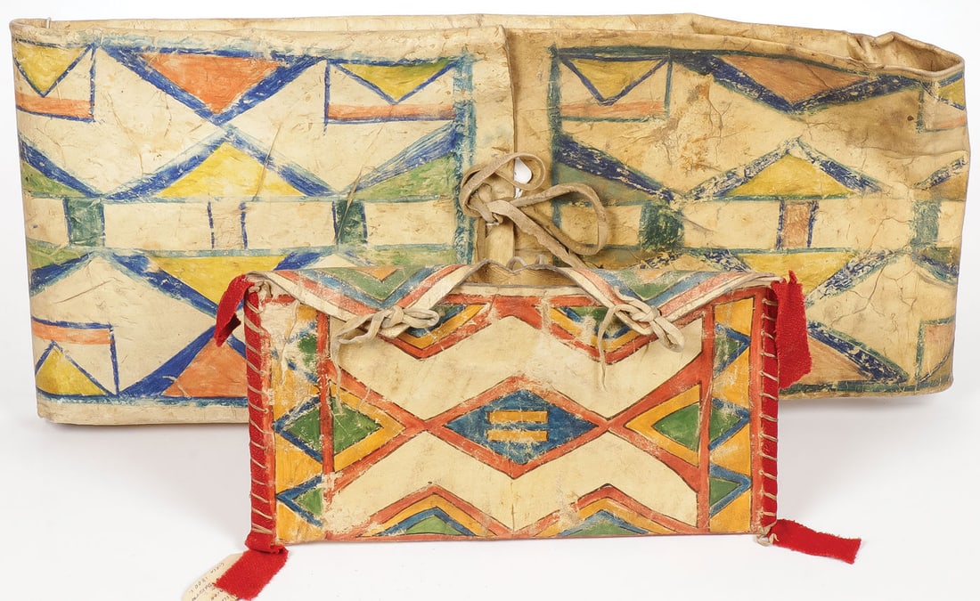 PR OF PLAINS PARFLECHE HOLDERS: PR OF PLAINS PARFLECHE HOLDERS. Including a larger envelope with traditional painted designs and original tanned hide tiedowns, circa 1880, 26 inches x 11.5 inches. Together with smaller parfleche pou
