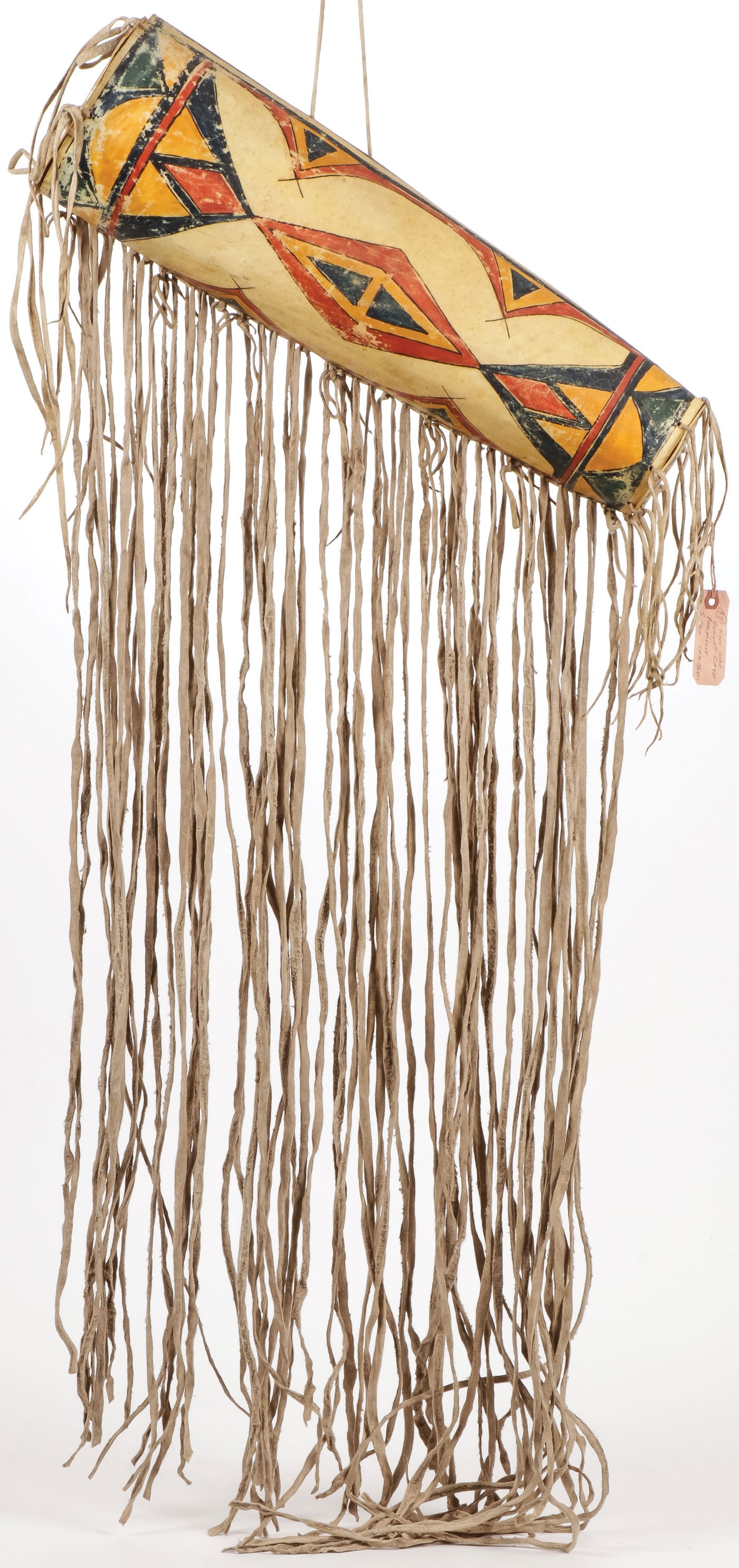 A PLAINS STYLE PARFLECHE CYLINDER: A PLAINS STYLE PARFLECHE CYLINDER. Of traditional form with painted geometric patterns and tanned hide fringe, retaining top and bottom covers. Length of cylinder 21.5 inches, overall length with frin
