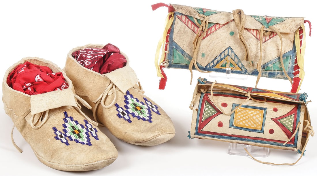 MOCCASINS AND PARFLECHE CONTAINERS: MOCCASINS AND PARFLECHE CONTAINERS. Comprising a pair of soft soled beaded hide moccasins and two parfleche containers. The pouch with trade wool edging and silk ribbons and the box with blue trade wo