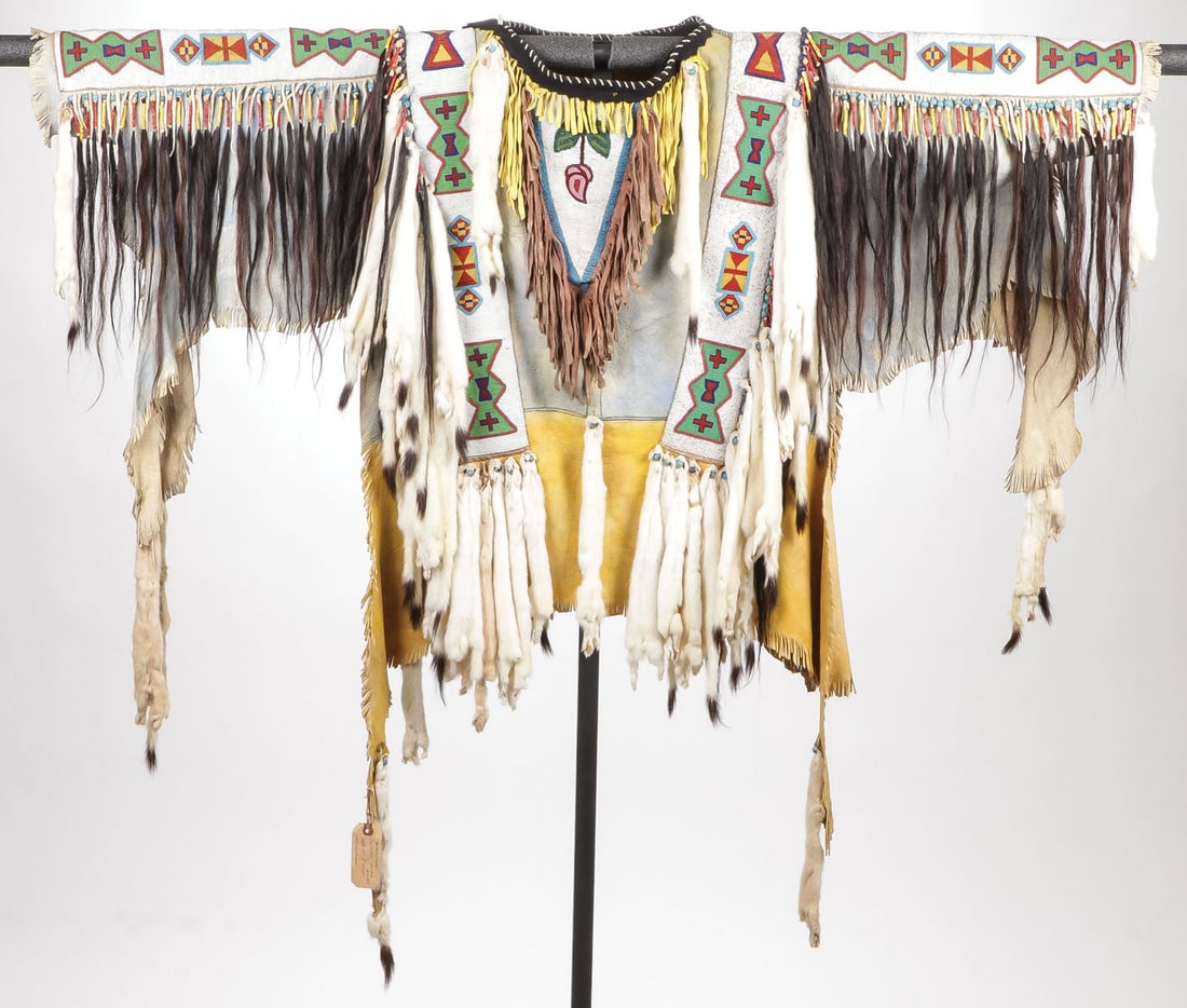 BEAUTIFUL PLAINS STYLE WAR SHIRT: BEAUTIFUL PLAINS STYLE WAR SHIRT. Comprising an impressive and finely crafted handmade traditional men's Plains style war shirt with ochre-dyed tanned hide. Finely beaded sleeves, breast, and side pan