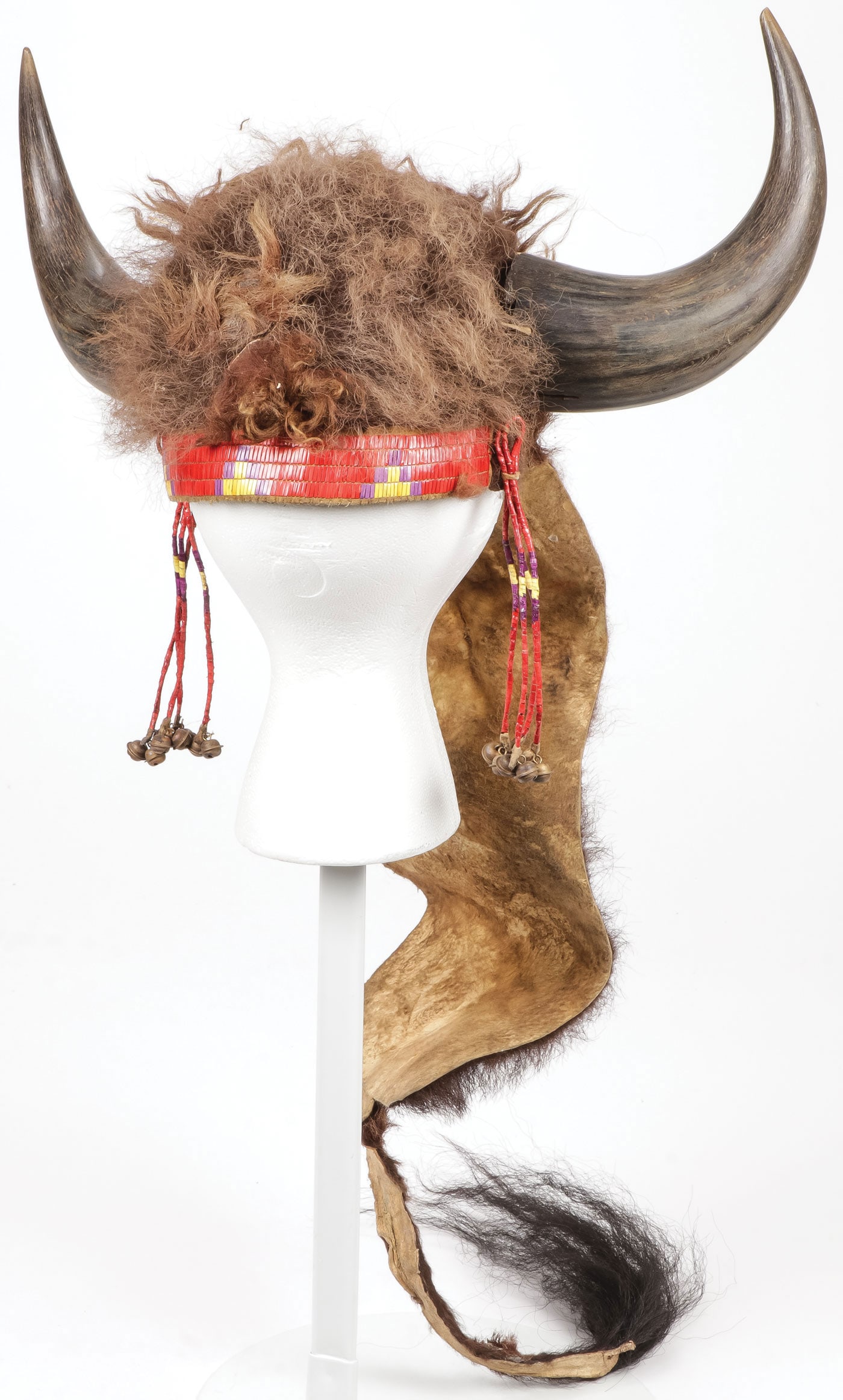 SIOUX STYLE BUFFALO BONNET: SIOUX STYLE BUFFALO BONNET. Of traditional design with quilled headband and quilled drops, terminating in brass bells. Sinew-sewn with traditional buffalo hide trailer terminating in buffalo tail. Ove
