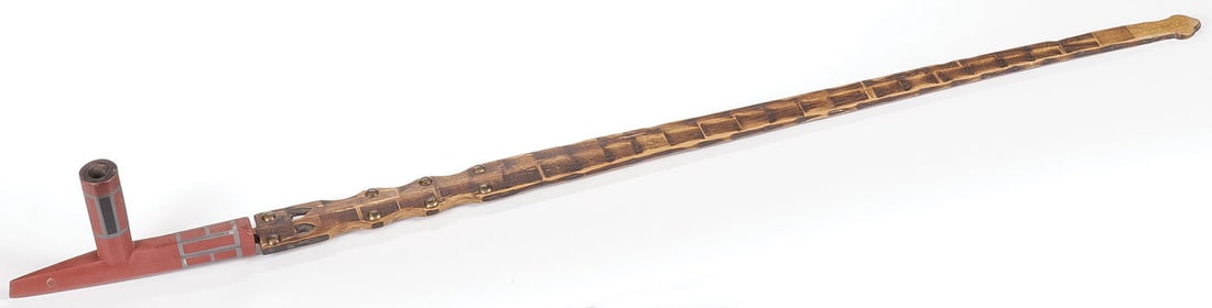 A PLAINS PIPE BOWL AND STEM, 19TH C: A PLAINS PIPE BOWL AND STEM, 19TH C. The catlinite bowl of traditional form, banded with inlaid pewter (the bowl has been broken and reglued) and with good vintage file-burned wood stem with brass tac