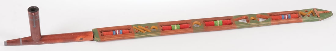 A CATLINITE PIPE BOWL AND STEM: A CATLINITE PIPE BOWL AND STEM. The bowl of traditional form with inlaid pewter banding, circa 1890. Overall length 10.1 inches. Together with a carved polychrome "puzzle" stem with red trade wool and