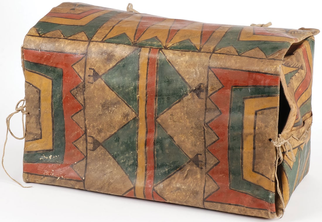 A PARFLECHE BOX: A PARFLECHE BOX. With painted geometric designs and hide straps. Height 12.75 inches, width 21.5 inches, depth 10.75 inches. SHIPPING NOTICE: Except for large, oversized items, Jackson's is your sole