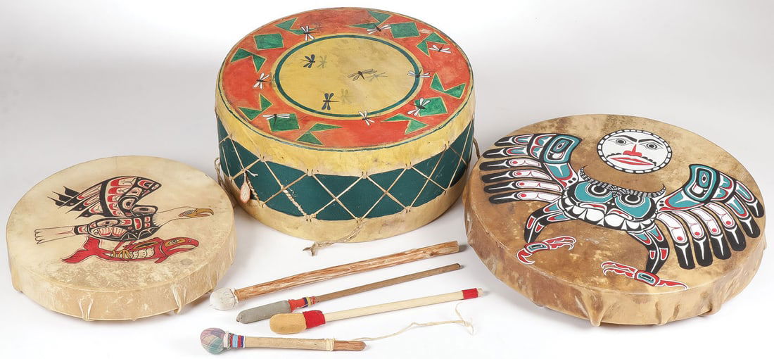THREE NATIVE HIDE DRUMS: THREE NATIVE HIDE DRUMS. Comprising a large Plains-style medicine drum with spirit dragonflies and wool-wrapped side. Together with two Northwest coast hand drums, probably Haida and four padded drums