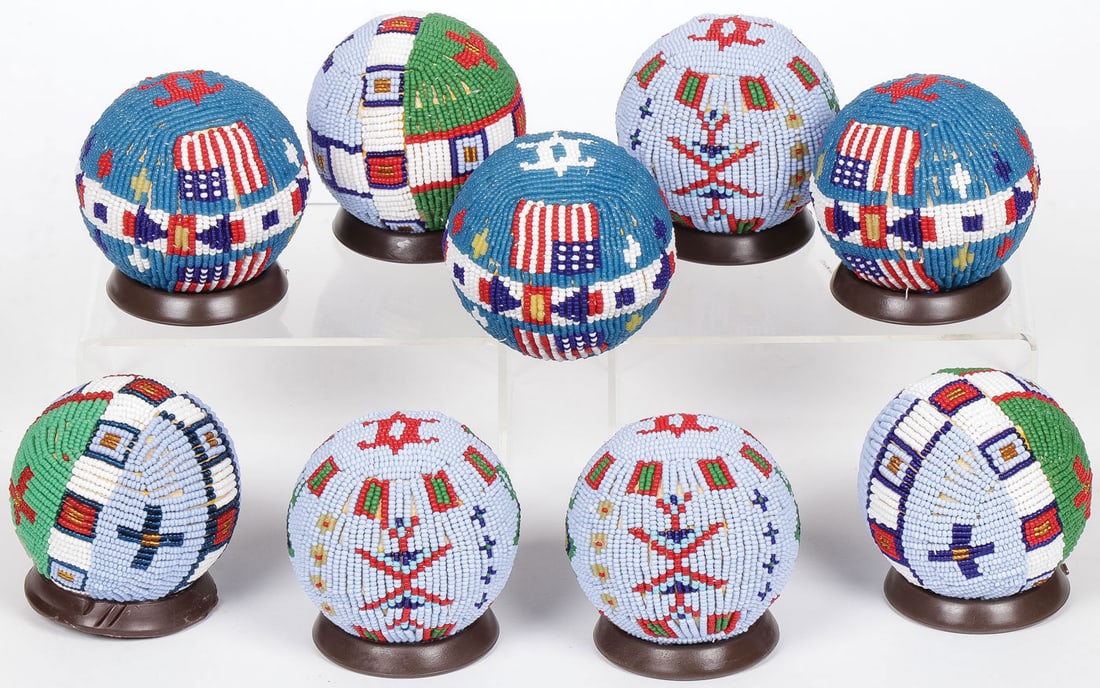 NINE PLAINS STYLE BEADED BALLS: NINE PLAINS STYLE BEADED BALLS. With various geometric and animal patterns as well as American flags. Each is approximately 2.5 inches. Contemporary. SHIPPING NOTICE: Except for large, oversized items