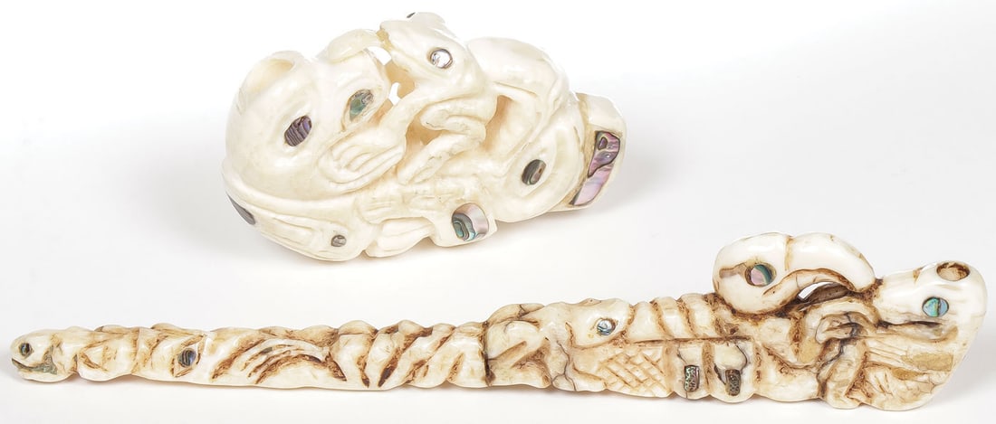 PAIR NORTHWEST COAST STYLE CARVED WALRUS PIPES: PAIR NORTHWEST COAST STYLE CARVED WALRUS PIPES. Comprising two Tlingit or Haida style carved walrus tusk pipes. The longest with carved stem and bowl depicting various creatures and inlaid with nacre.