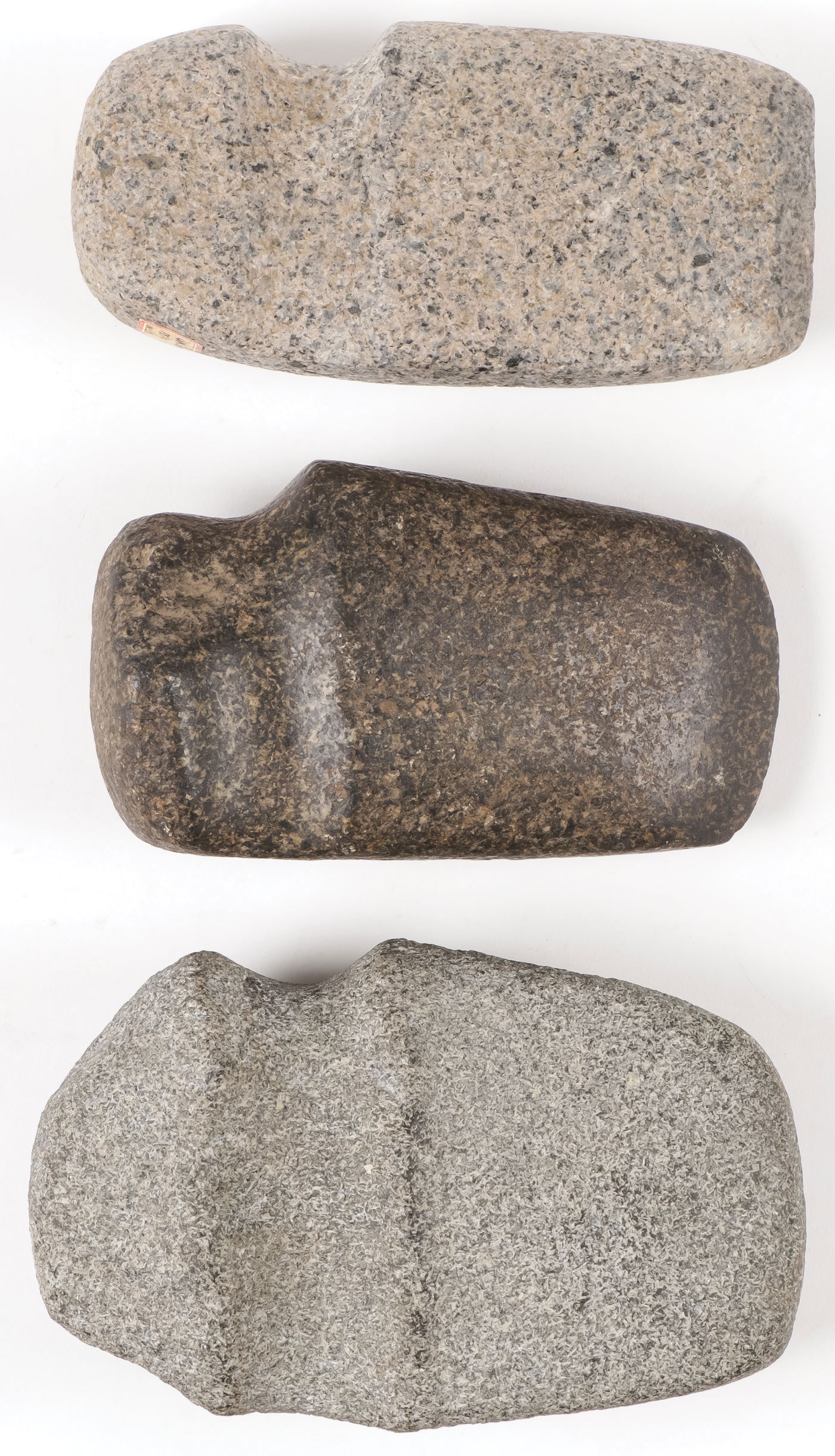 THREE STONE AXE HEADS: THREE STONE AXE HEADS. The largest three-quarter groove with fluting, a polished three-quarter and another as shown. Greatest length 6.25 inches. SHIPPING NOTICE: Except for large, oversized items, Ja