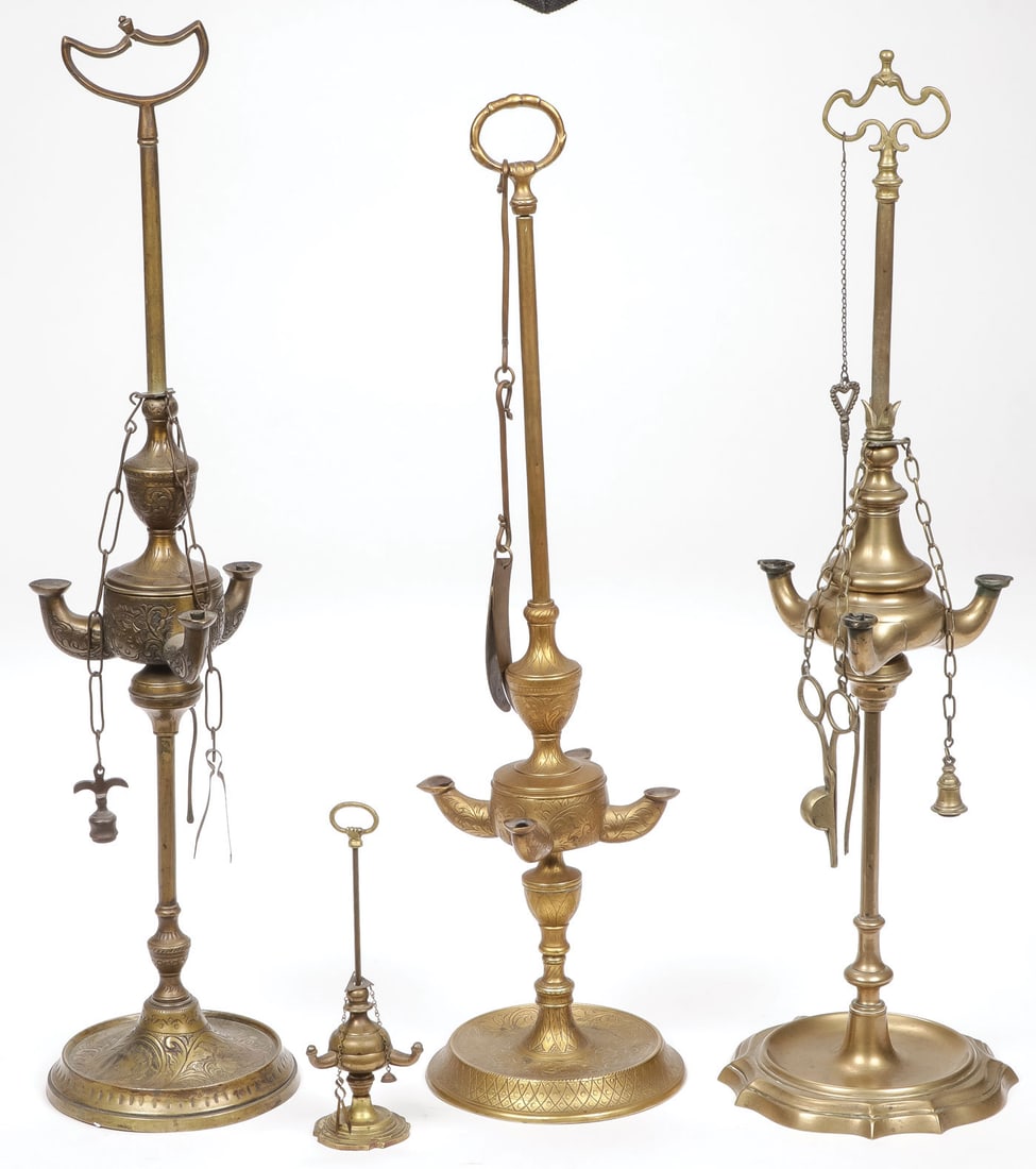 FOUR VINTAGE LUCERNE OIL LAMPS: FOUR VINTAGE LUCERNE OIL LAMPS. Each of traditional design, various sizes, with chain attached accoutrements. The base of one engraved with the Chi-rho symbol. Greatest height 24 inches. SHIPPING NOTI