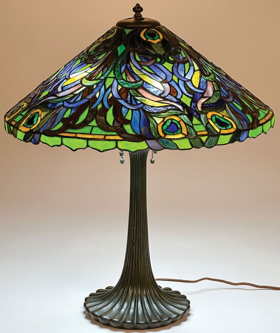 ATTRIBUTTED DUFFNER & KIMBERLY PEACOCK LEADED TABLE LAMP: ATTRIBUTTED DUFFNER & KIMBERLY PEACOCK LEADED TABLE LAMP. Comprising a finely crafted leaded glass conical shade in the peacock pattern, resting on a ?Japanese' tapering fluted patinated bronze base w
