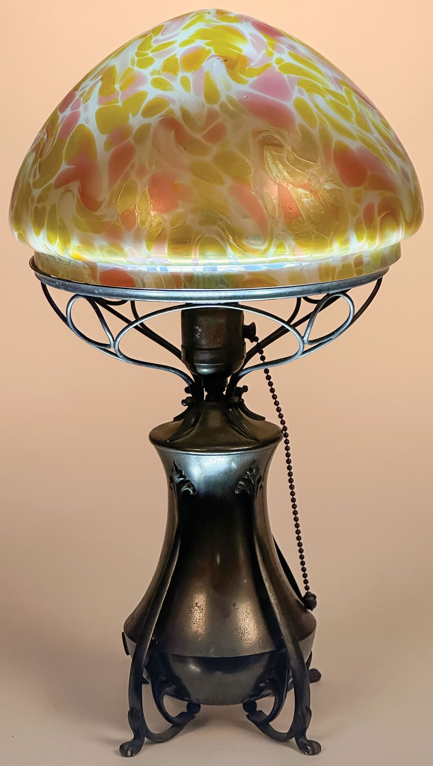 ART GLASS TABLE LAMP, C. 1910: ART GLASS TABLE LAMP, C. 1910. With unmarked iridized oil spot conical shade resting on a silver-plated single socket unmarked lamp base. The fitter ring slightly small for the shade, overall height 1