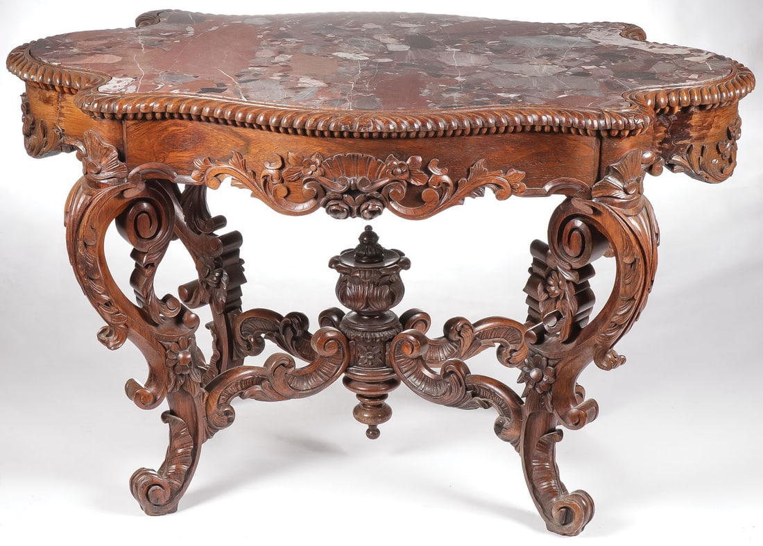 ROCOCO REVIVAL ROSEWOOD PARLOR TABLE: ROCOCO REVIVAL ROSEWOOD PARLOR TABLE. Heavily carved scroll legs, and conforming stretchers terminating on carved pedestal with flowerhead finial. Heavily carved skirt with gadrooned edge. The top wit