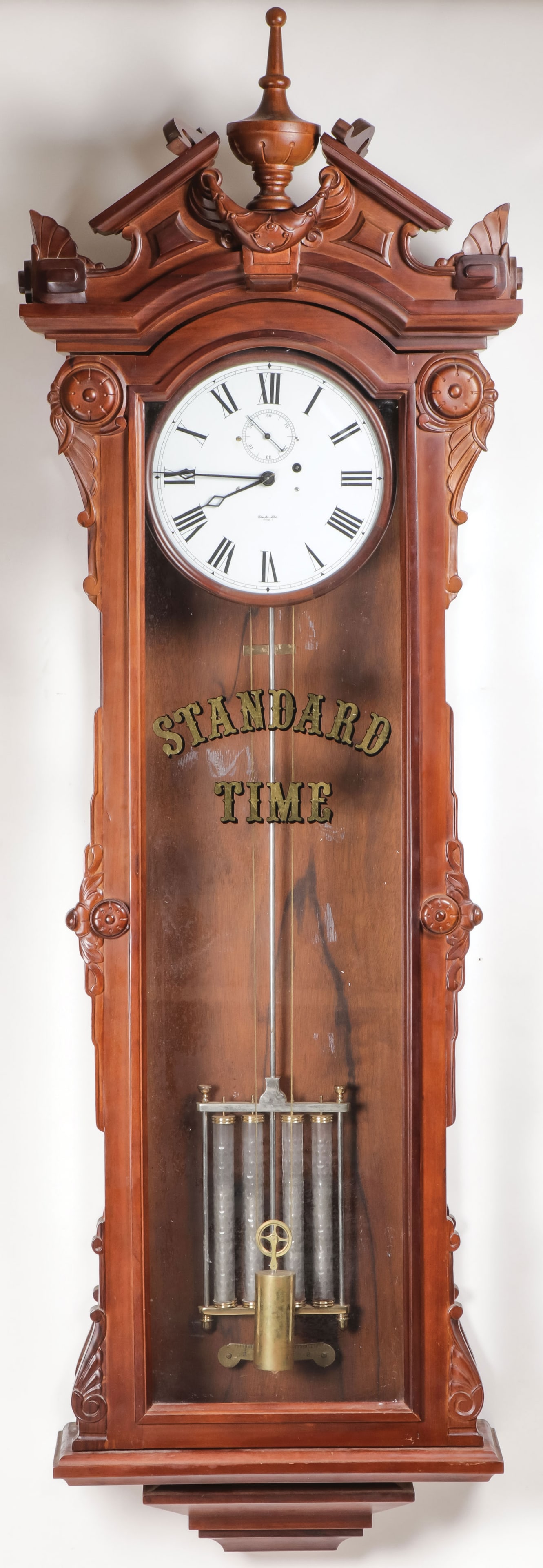 LARGE WALNUT REGULATOR CLOCK: LARGE WALNUT REGULATOR CLOCK. Comprising a large walnut regulator clock. Triangle Pediment with turned finial above carved swags, the sides carved with rosettes and acanthus. The glass door with gilde