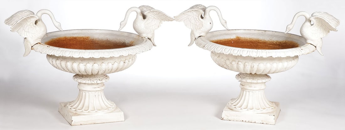 PAIR CAST IRON SWAN GARDEN URNS: PAIR CAST IRON SWAN GARDEN URNS. Of traditional style with ribbed bodies, the rims set with opposing swans with outstretched wings. Height 27 inches, greatest width (wingtip to wingtip) 39 inches. LOC