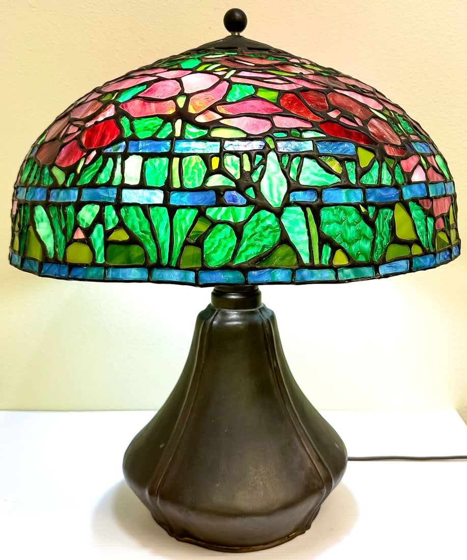 AN AMERICAN LEADED LAMP ON B & H BASE: AN AMERICAN LEADED LAMP ON B & H BASE. Comprising a patinated Bradley & Hubbard Arts and Crafts style bulbous form lamp base with double gooseneck light cluster and adjustable stem. Set with a finely 