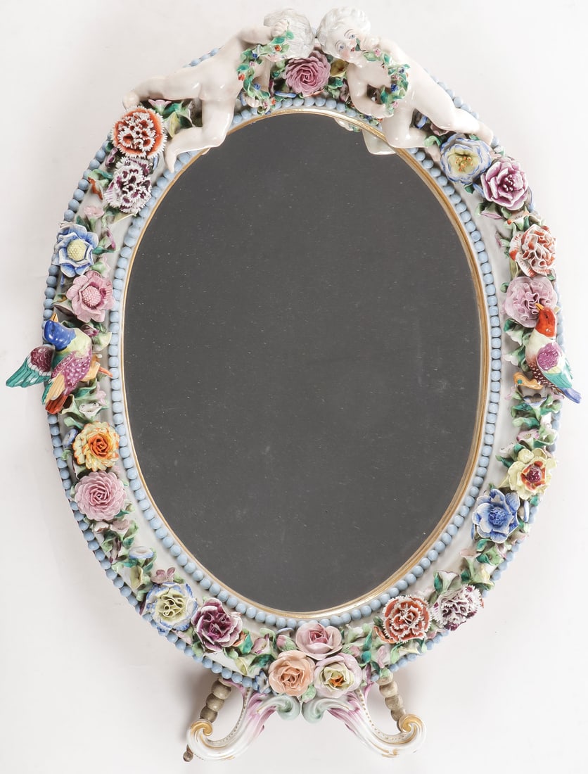 A FINE MEISSEN FLORAL TABLETOP MIRROR, 19TH C: A FINE MEISSEN FLORAL TABLETOP MIRROR, 19TH C. The oval frame with turquoise beaded borders, set with a profusion of multicolored flowers and birds and at top two putti with floral garland. The wooden