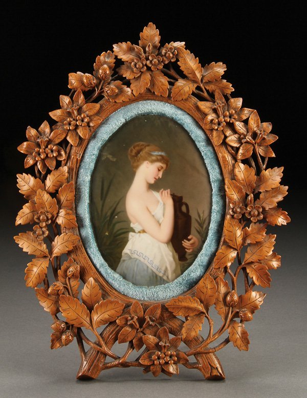 A BERLIN KPM HAND PAINTED PORCELAIN PLAQUE: A BERLIN KPM HAND PAINTED PORCELAIN PLAQUE, LATE 19TH CENTURY. Of a classical young beauty with urn painted on an oval porcelain plaque impressed "KPM" on verso and contained in a well carved fruitwoo