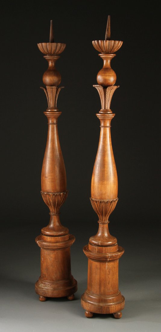 PAIR OF CONTINENTAL WOOD CANDLE PRICKETS: A PAIR OF 18TH/19TH CENTURY CONTINENTAL WOOD CANDLE PRICKETS. Of turned baluster form, raised on circular plinths surmounted with carved plumes and bulbous terminals with scalloped candlestands. Heigh