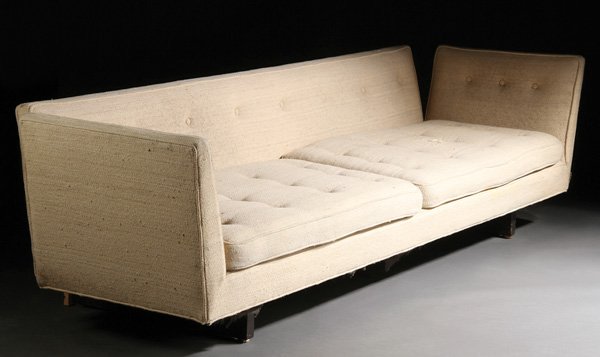 SOFA, EDWARD WORMLEY FOR DUNBAR: EDWARD WORMLEY FOR DUNBAR, SOFA, MID 20TH CENTURY. With tufted back, sides and cushions. Upholstered in cream fabric with angled arm rests and on dark-stained legs.