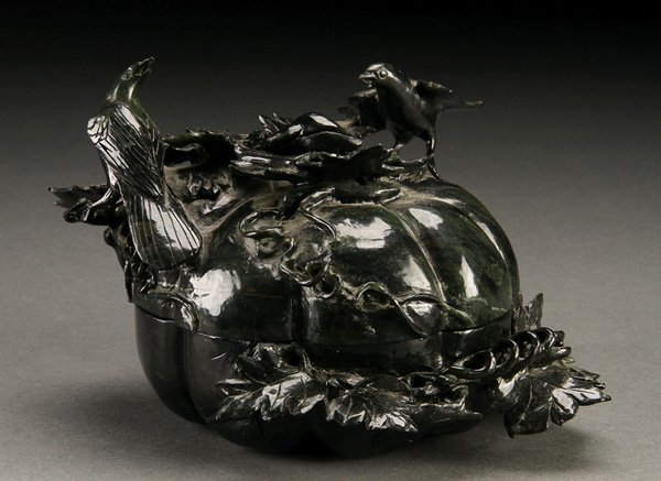 A CHINESE CARVED HARDSTONE LIDDED BOX, 20TH C.: A CHINESE CARVED HARDSTONE LIDDED BOX, 20TH CENTURY. Carved in spinach green colored hardstone in the form of a large squash with grape vines and figural birds. Height 4.75 inches (12 cm).