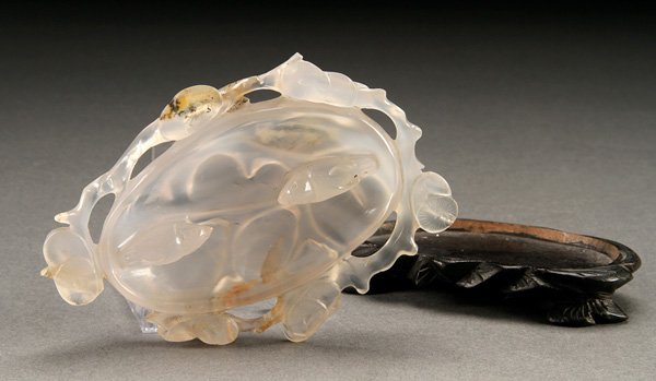 A CHINESE CARVED CARNELIAN BRUSH WASHER, 20TH: A CHINESE CARVED CARNELIAN BRUSH WASHER, 20TH CENTURY. Carved in the form of a peach with two birds, blossoms and vines. Minor loss. Raised on a conforming carved hardwood stand. Length 4.5 inches (11