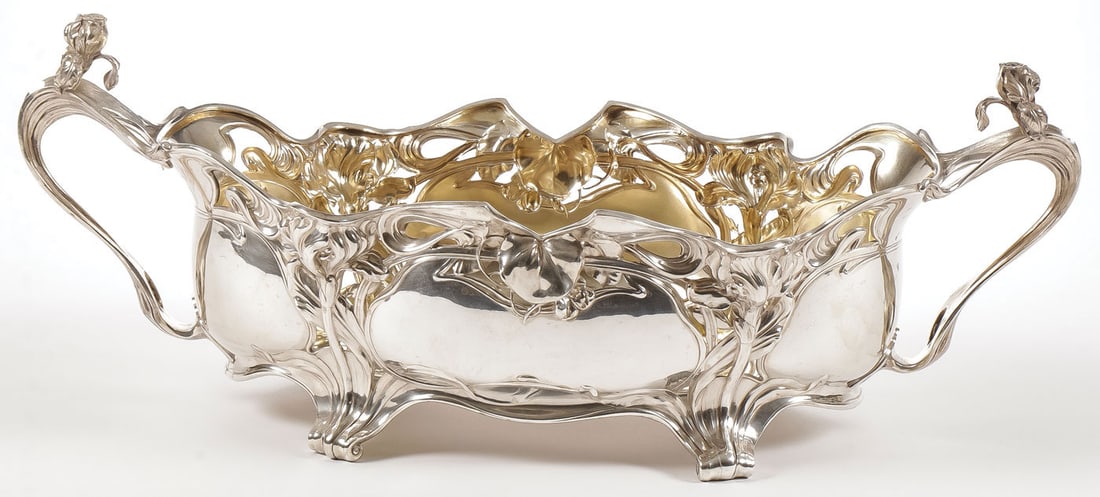 IMPRESSIVE ART NOUVEAU SILVER CENTERPIECE: IMPRESSIVE ART NOUVEAU SILVER CENTERPIECE, CIRCA 1890. Resting on four scroll feet, the sides pierced and repousséd with strapworks and flowers in the Art Nouveau style. Whiplash handles set with
