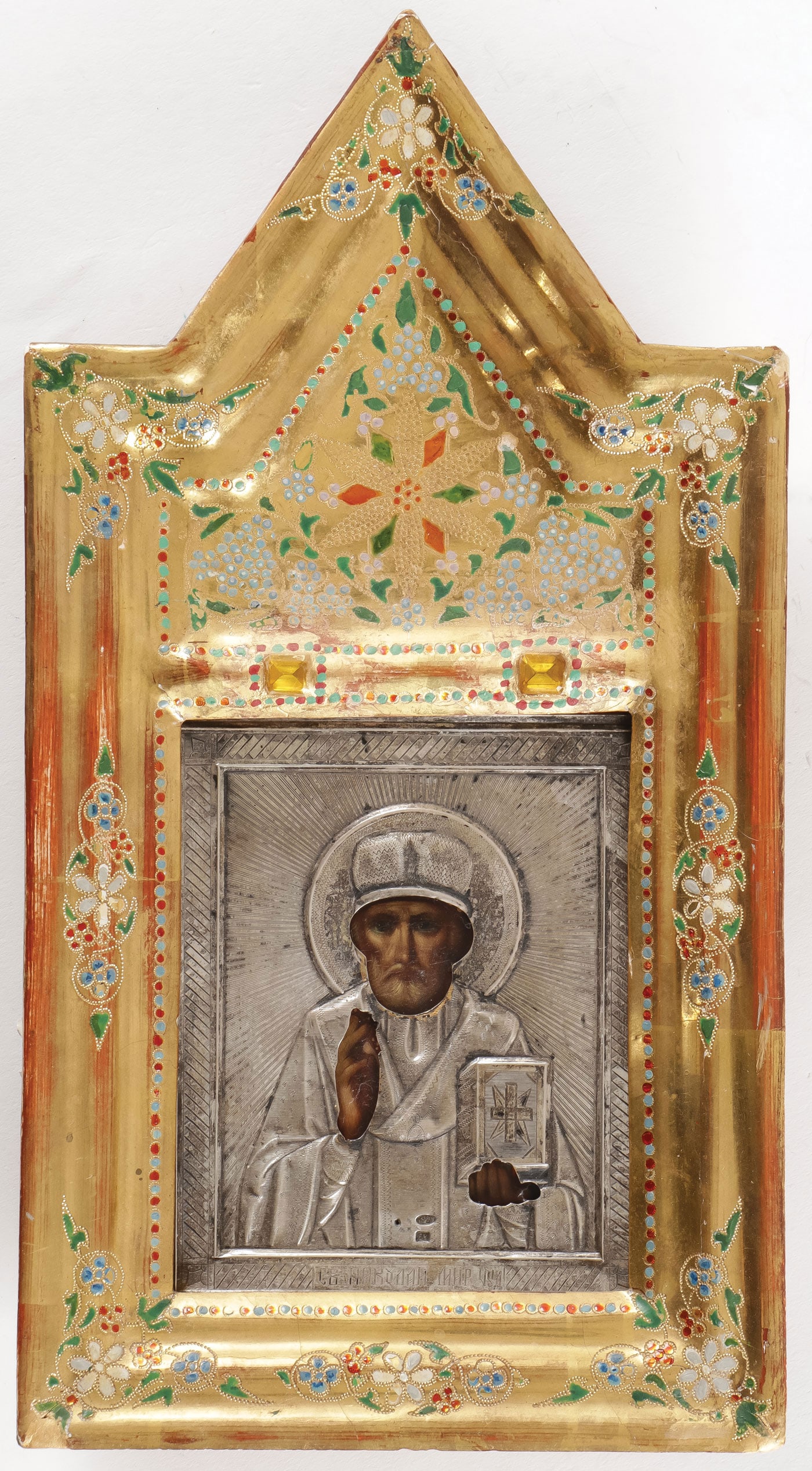 RUSSIAN ICON OF SAINT NICHOLAS: RUSSIAN ICON OF SAINT NICHOLAS. Comprising a traditional icon of Saint Nicholas overlaid with a machine engraved silver oklad, hallmarked Moscow, 1908-1917, 84 silver-standard, and indistinguishable m