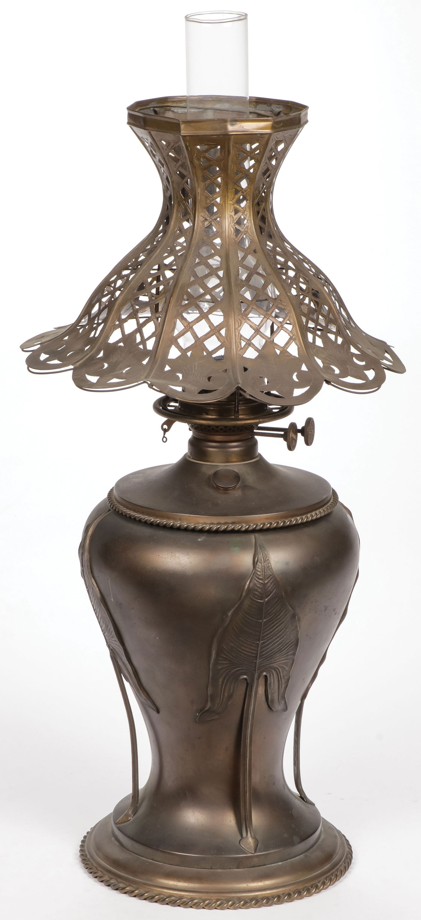 A BRADLEY & HUBBARD OIL LAMP: A BRADLEY & HUBBARD OIL LAMP. The bronze patinated vase form base within a leaf-form framework and with rope twist border, the burner knobs marked B Deluxe H, and with a likely associated reticulated 