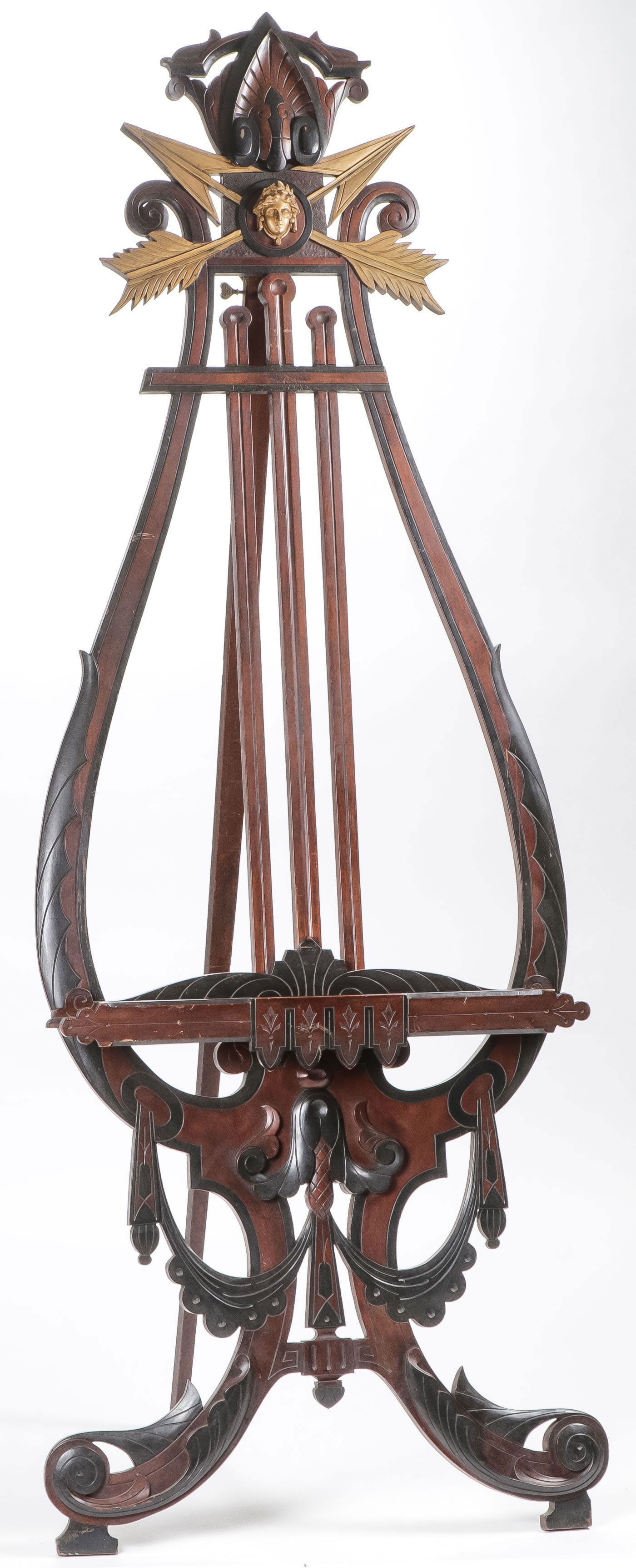 EXCEPTIONAL WALNUT LYRE SHAPE EASEL, C. 1880: EXCEPTIONAL WALNUT LYRE SHAPE EASEL, C. 1880. Comprising a large and impressive walnut and gilt decorated incised lyre form adjustable parlor easel. Height 80 inches. Width 25 inches. NO RESERVE. LOCA