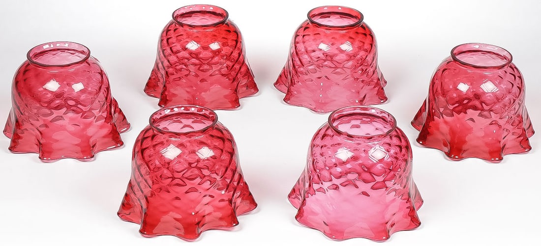 SIX RUBY DIAMOND QUILTED LAMPSHADES: SIX RUBY DIAMOND QUILTED LAMPSHADES. Each swirl pattern with flared ruffled rim. Height 6.25 inches. Greatest diameter 8 inches. Fitter ring 4 inches. NO RESERVE.SHIPPING NOTICE:Except for large, ov