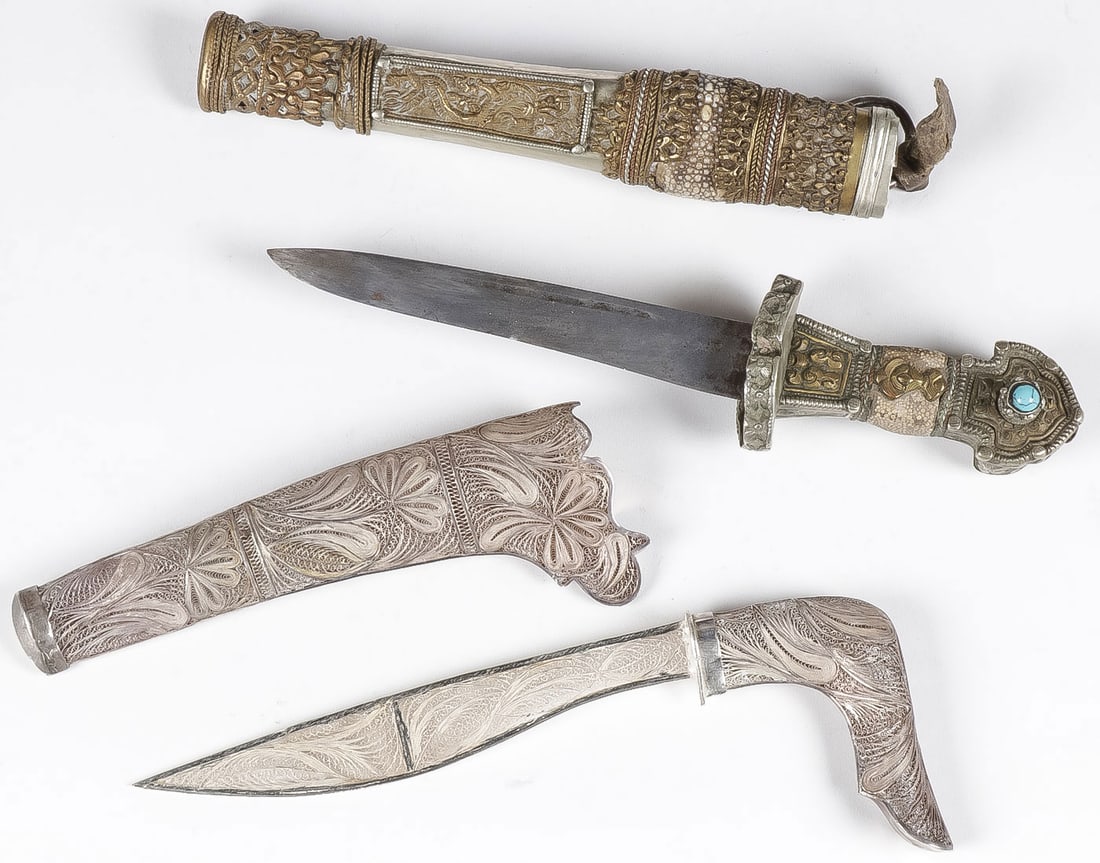 VINTAGE ASIAN DAGGERS: VINTAGE ASIAN DAGGERS. Comprising an ornate Tibetan dagger with shark skin and turquoise decoration overall length in sheath 13.75 inches (35 cm). Together with a presumably silver filagree dagger wit
