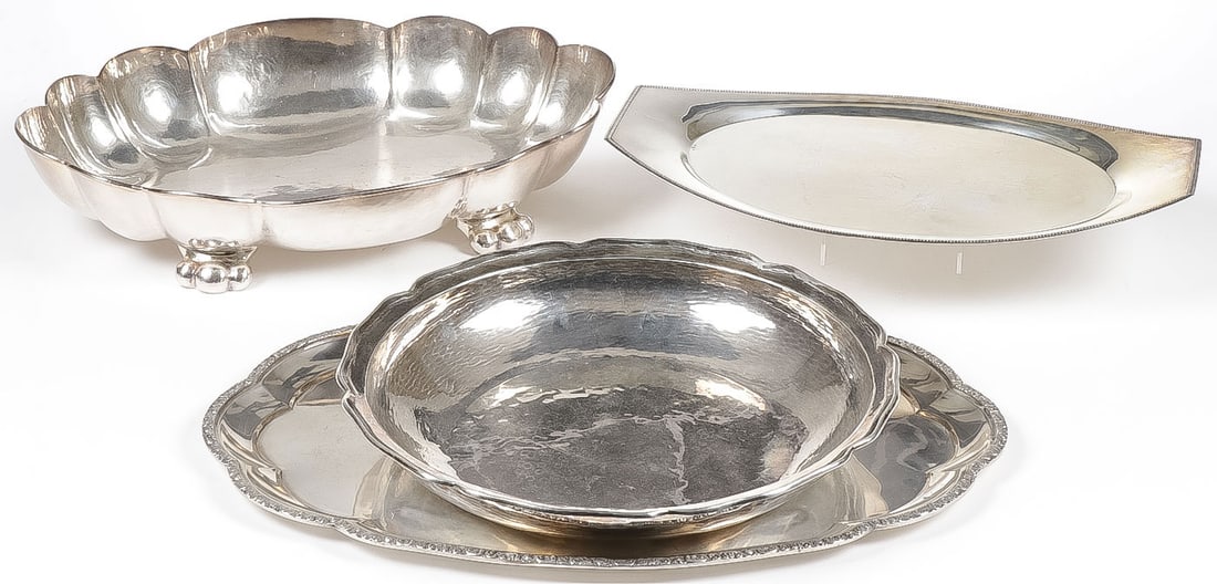 FOUR LARGE SILVER TRAYS: FOUR LARGE SILVER TRAYS. Comprising a ribbed footed serving tray (upper left) marked .800, an oval tray with squared ends (top right) Austrian hallmarks for .800 silver, a large hammered circular bowl