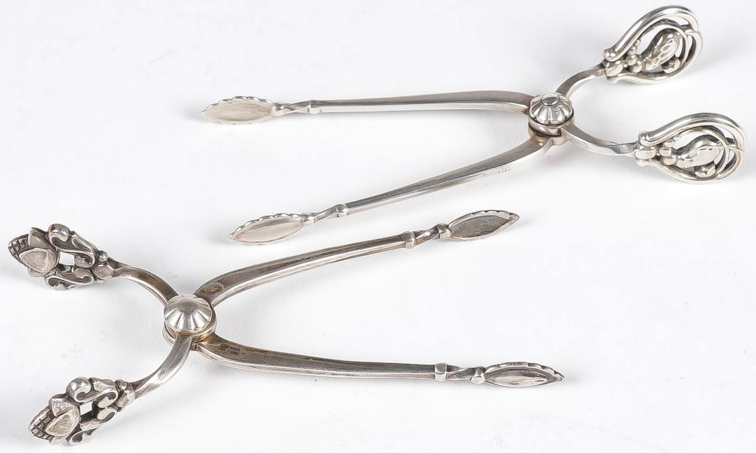 PR GEORG JENSEN STERLING SUGAR TONGS: PR GEORG JENSEN STERLING SUGAR TONGS. Both with Georg Jensen marks, one marked sterling the other .925. Length 4 inches. Total weight 47 grams. NO RESERVE. Provenance: The Doctor Manmohan Singh MD (1