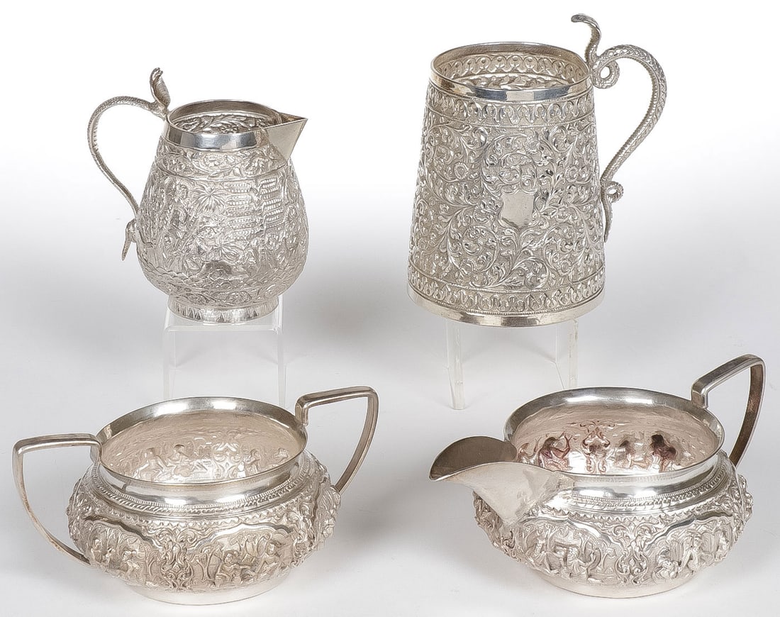 ANGLO INDIAN COIN SILVER: ANGLO INDIAN COIN SILVER. Comprising four individual pieces including a matching creamer and sugar, a creamer with cobra handle and a tapered mug with coiled snake handle. Each piece is heavily decora
