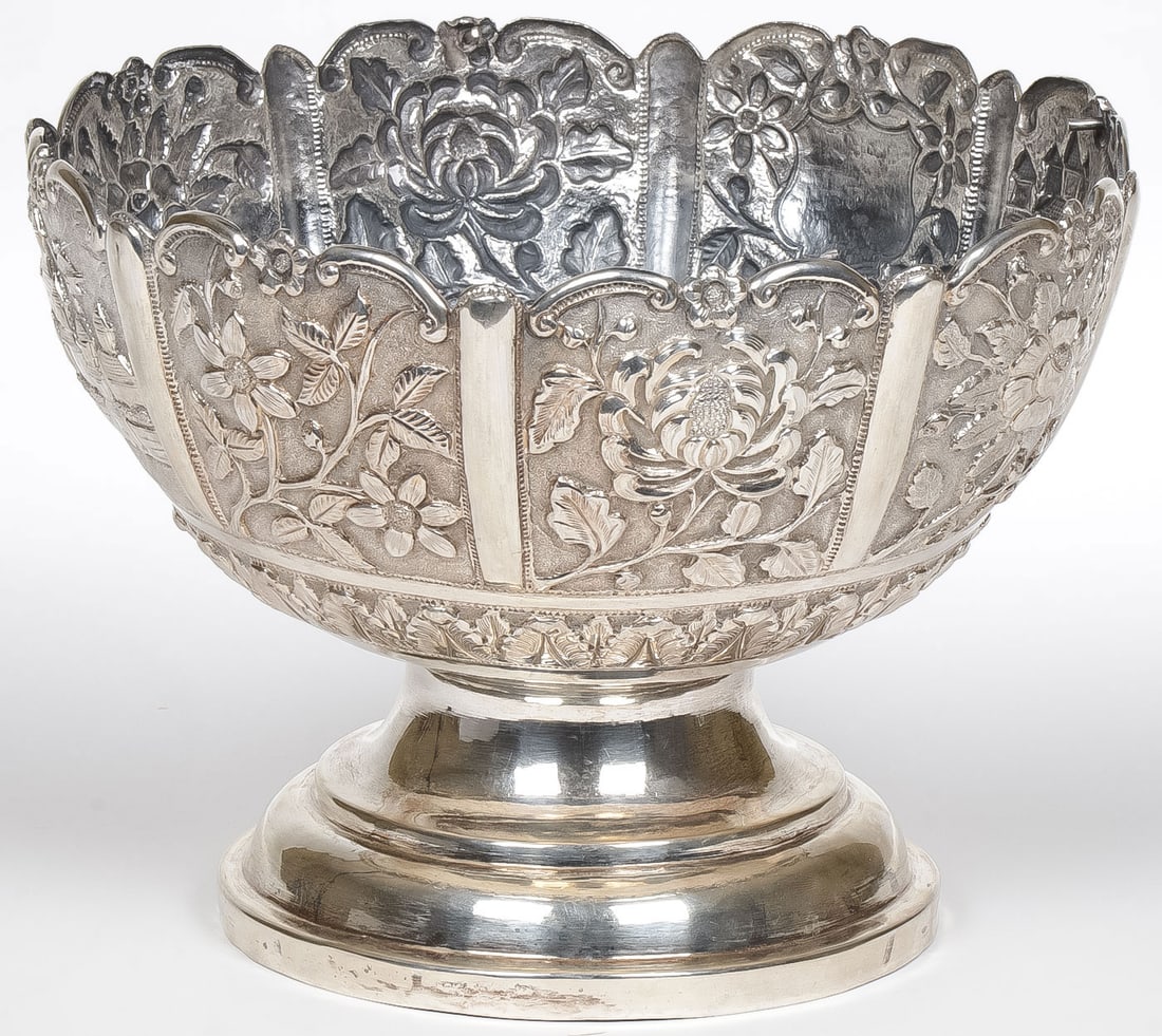 LARGE INDIAN/ASIAN BOWL: LARGE INDIAN/ASIAN BOWL. Comprising a large and impressive footed fruit bowl with heavily repoussed panels including a fenced compound? flying the Union Jack. Unmarked but it tests silver. Height 7.75