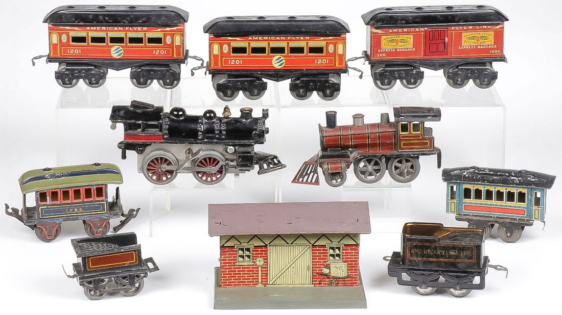VINTAGE TOY TRAIN GROUP: VINTAGE TOY TRAIN GROUP. Comprising 10 individual pieces including a cast iron key wind locomotive (length 8 inches), a tin key wind locomotive with matching coal tender, 3 tin American Flyer cars, an
