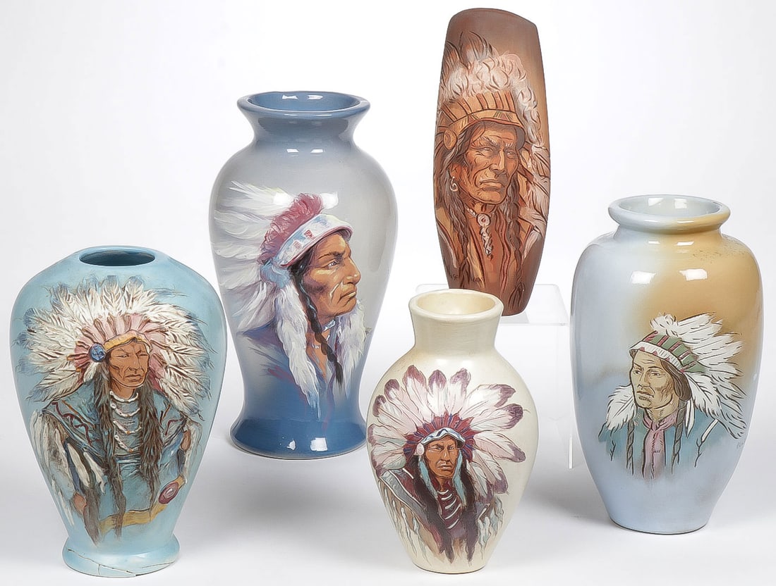 FIVE WIHOA POTTERY VASES: FIVE WIHOA POTTERY VASES. Of various sizes each decorated with Native Americans wearing feathered bonnet. The largest example (second from left) artist signed Rick Wisecarver, example at lower left wi