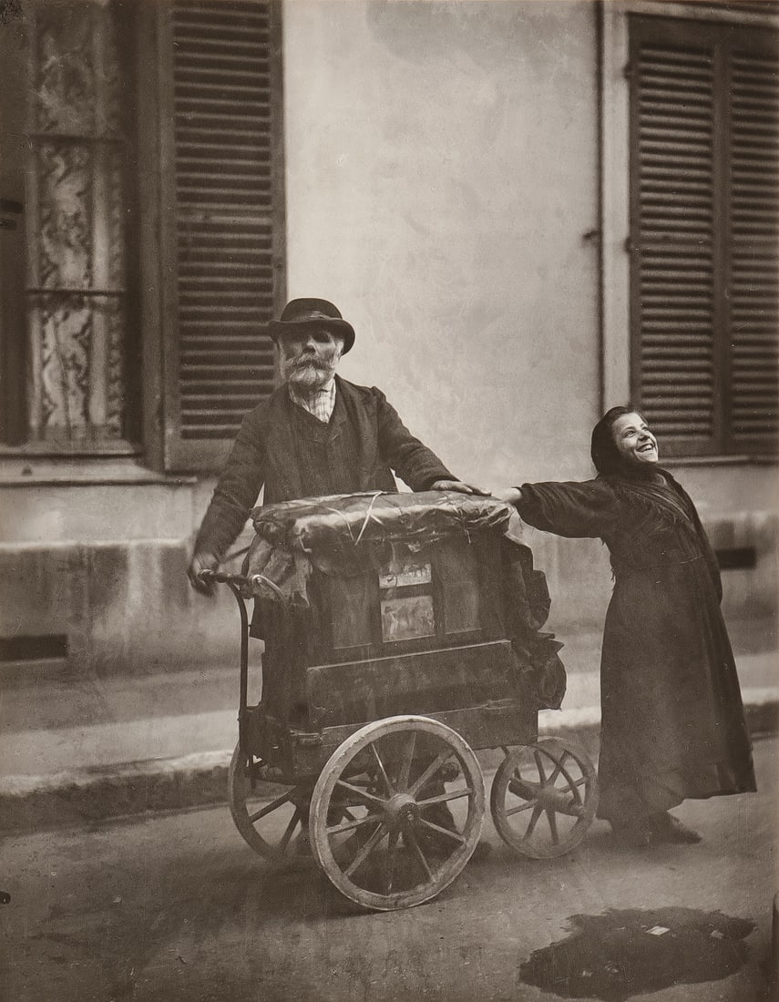 EUGENE ATGET PHOTOGRAPH ORGAN GRINDER: EUGENE ATGET (French 1857-1927)The Organ Grinder Silver print mounted on card, circa 1960 by Berenice AbbottVerso stamped "Photograph by Eugene Atget Copyright Berenice Abbott Reproduction Rights Res