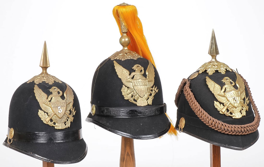 THREE U.S. INDIAN WARS M1881 HELMETS: THREE U.S. INDIAN WARS M1881 HELMETS. Comprising a good group of three helmets, each with dark blue cloth bodies, the example at left with infantry eagle plate with the regimental number 5, oakleaf pl