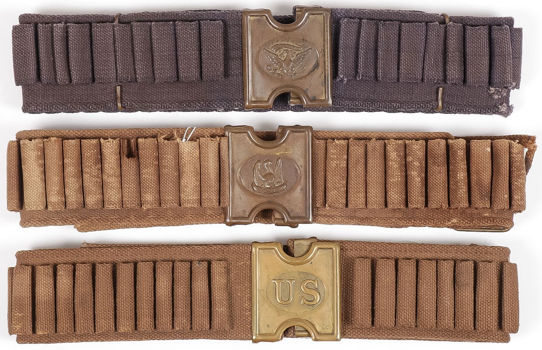 3 MILLS PRAIRE BELTS AND BUCKLES: 3 MILLS PRAIRE BELTS AND BUCKLES. Comprising a blue calvary webbed cotton cartridge belt with variation of the M1881 pattern buckle, sometimes referred to as the "dog head" buckle. All the brass (buck