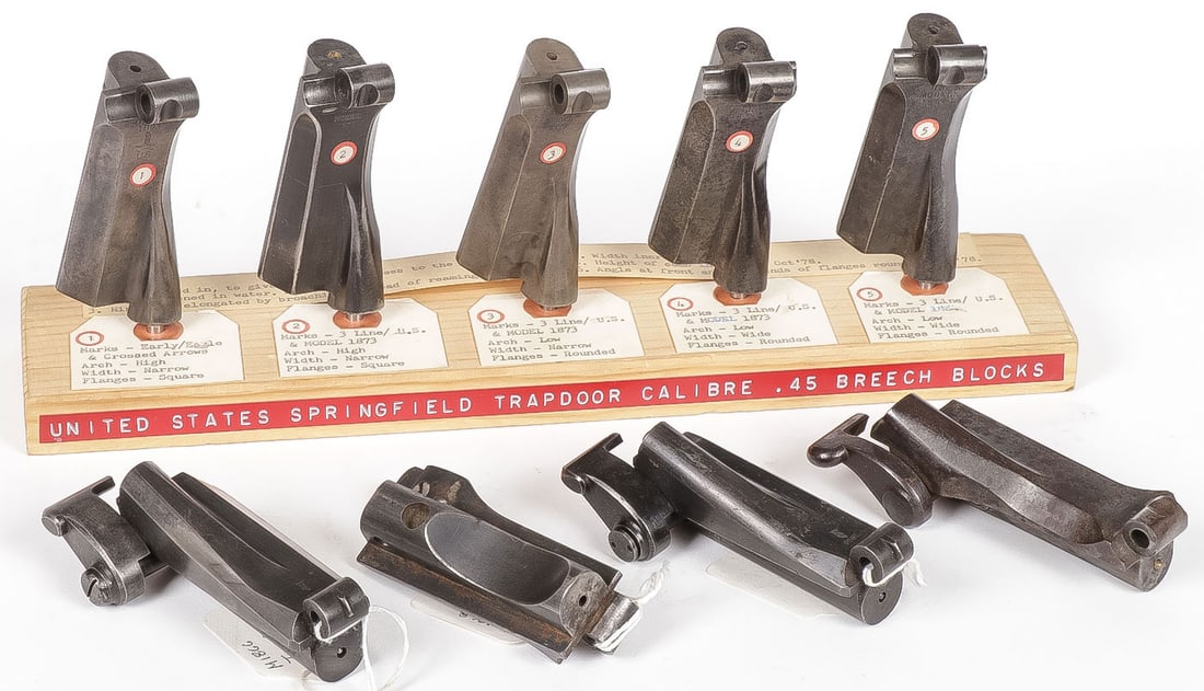 SPRINGFIELD TRAPDOOR BREECH BLOCKS: SPRINGFIELD TRAPDOOR BREECH BLOCKS. Comprising a good group of nine breech blocks. Five on wooden display stand identifying the slight variations from various types as shown. As well as four additiona
