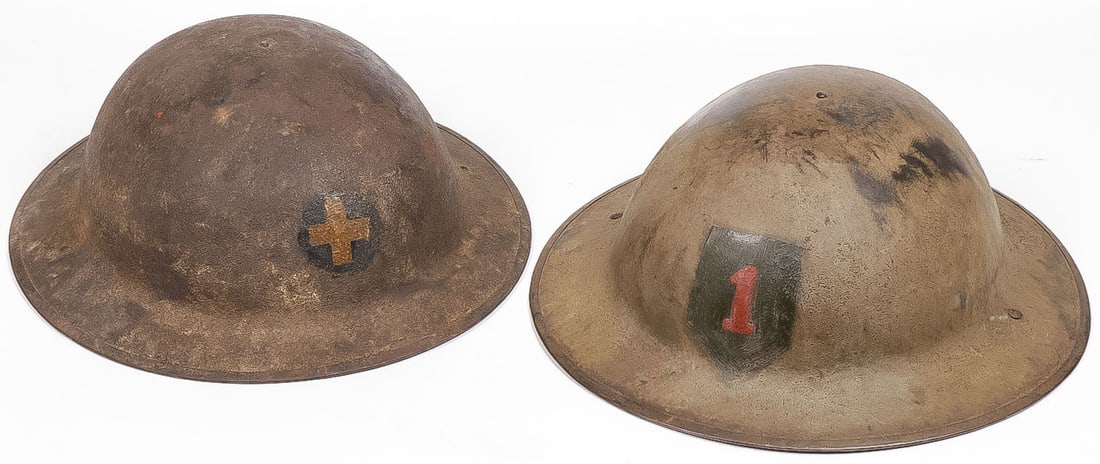 PAIR US WWI DIVISION PAINTED HELMETS: PAIR US WWI DIVISION PAINTED HELMETS. Comprising a pair of WWI Doughboy metal helmets with sand finish, one painted with First Infantry Division Insignia, the other 33rd Division Insignia, both with o