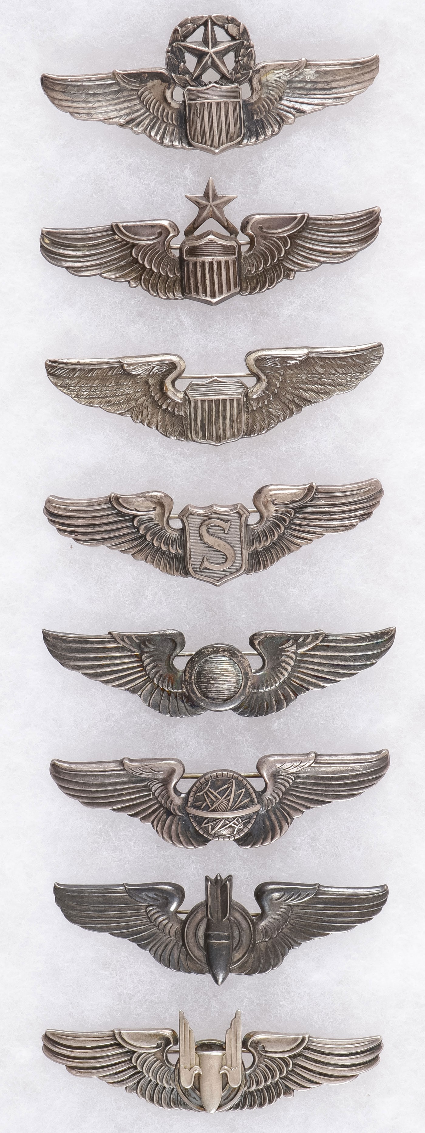 8 GOOD U.S. WWII STERLING AIR CORPS WINGS: 8 GOOD U.S. WWII STERLING AIR CORPS WINGS. Comprising a good group, various makers and variations including from top to bottom the following; a fine sterling marked 3 inch Command Pilot wings, clutch 