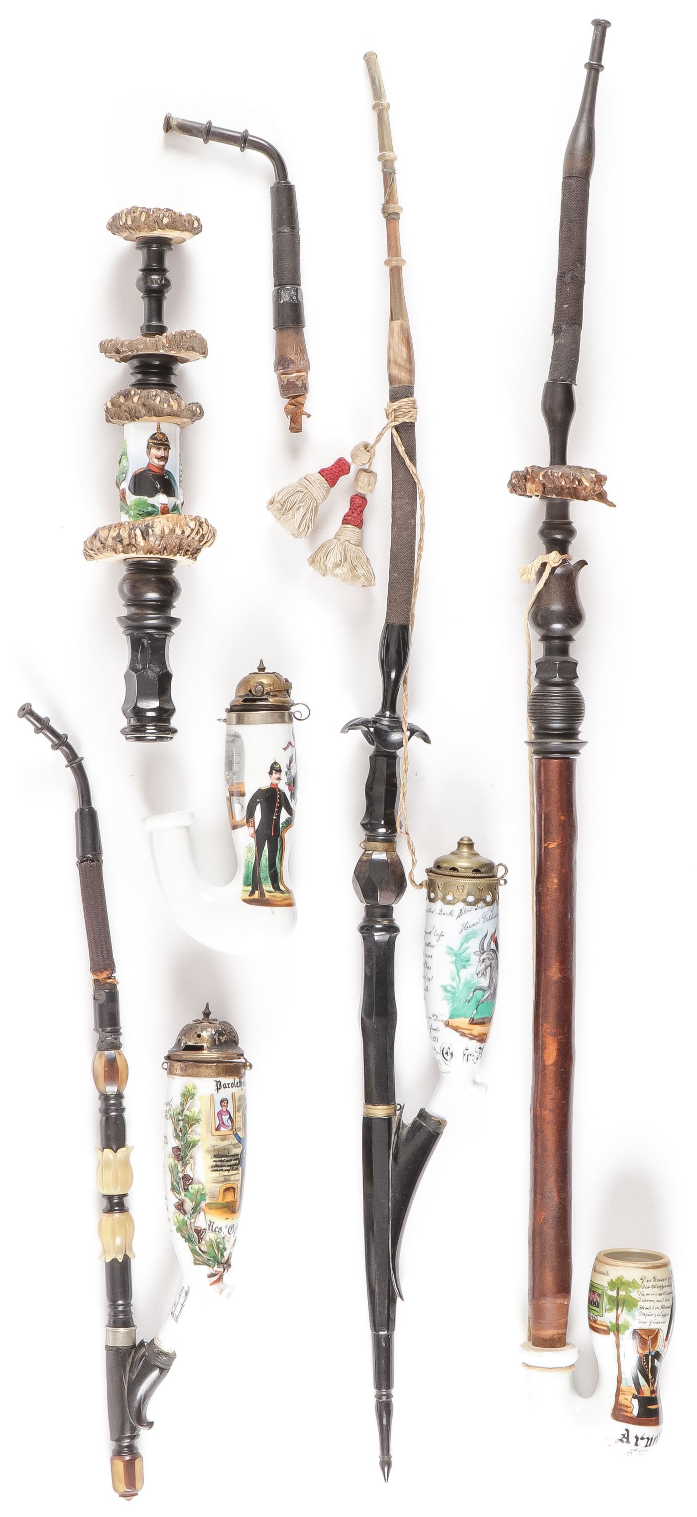 IMPERIAL GERMAN PORCELAIN RESERVIST PIPE BOWLS: IMPERIAL GERMAN PORCELAIN RESERVIST PIPE BOWLS & STEMS. Comprising a good group, including four porcelain pipe bowls on stems, two with pickelhaube hinged caps as shown, as well as stems and mouth pie