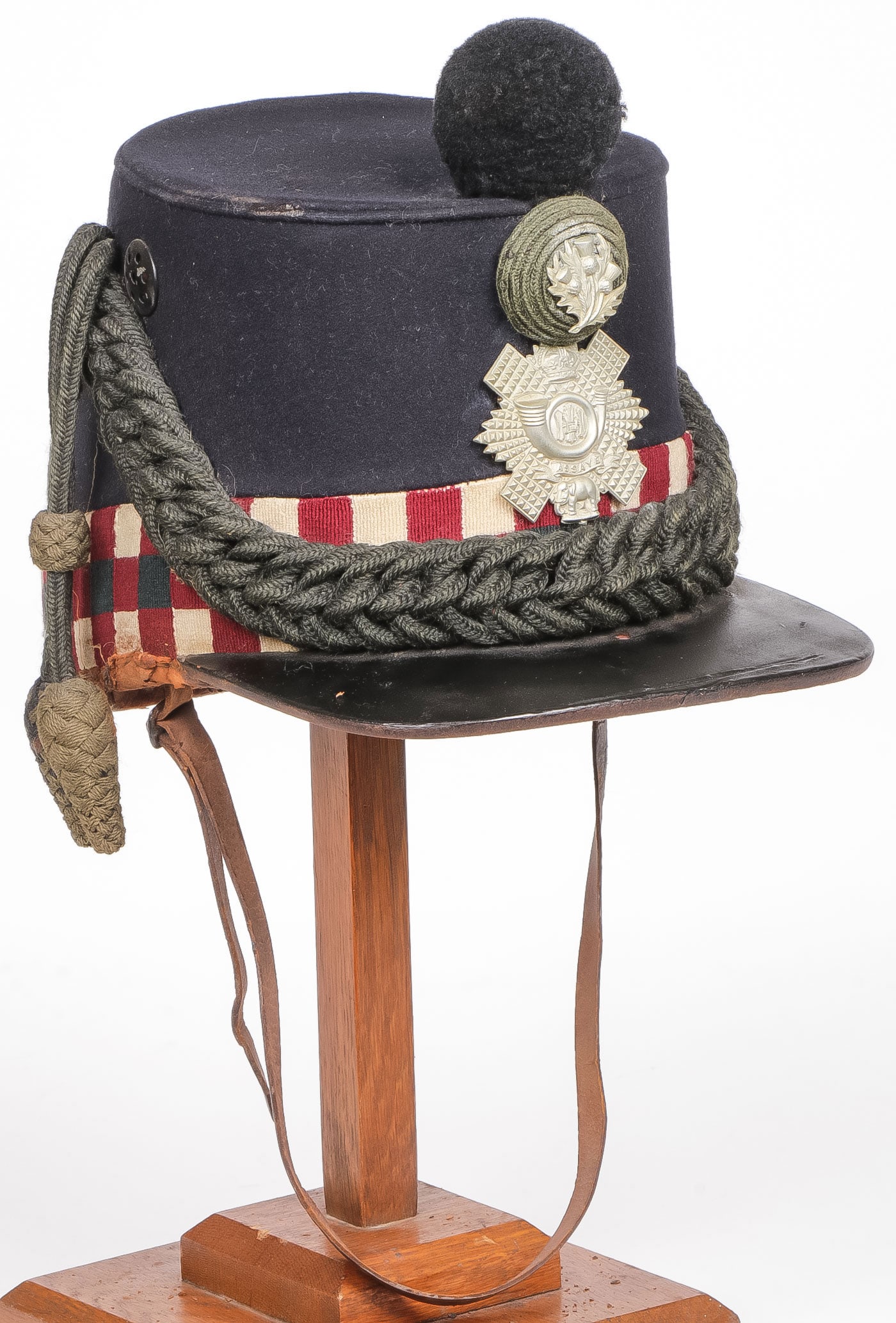 A HIGHLAND LIGHT INFANTRY ENLISTED SHAKO: A HIGHLAND LIGHT INFANTRY ENLISTED SHAKO. Victorian-era shako of an enlisted man of the Highland Infantry Regiment of the British Army, constructed of dark blue wool with a diced red, black and white
