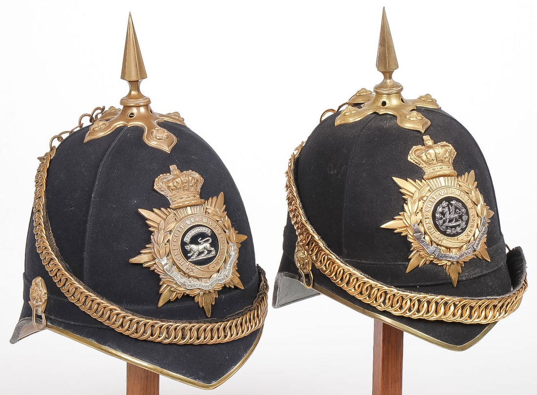 PAIR OF BRITISH OFFICERS HOME SERVICE HELMETS: PAIR OF BRITISH OFFICERS HOME SERVICE HELMETS, C 1890'S. Comprising two blue cloth home service helmets, each with velvet backed gilt chains, side rosettes, cross base with rosettes and spike. One wit