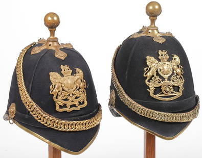 PAIR OF BRITISH OFFICERS HOME SERVICE HELMETS: PAIR OF BRITISH OFFICERS HOME SERVICE HELMETS, C 1890'S. Comprising a Royal Engineers blue cloth helmet, gilt metal Royal Engineers plate, leather backed gilt chains, side rosettes, cross base with ro