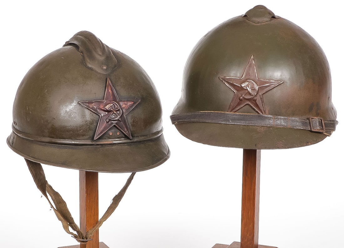PAIR OF EARLY RUSSIAN/RED ARMY HELMETS: PAIR OF EARLY RUSSIAN/RED ARMY HELMETS. Comprising a M 1916 helmet in original paint, applied metal star, leather strap and liner. The interior of rim inscribed in Russian "Proletarians of the world u